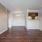 Spacious and well lit living room with wood flooring, large windows and open access to the kitchen