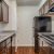 Spacious and well lit kitchen with wood flooring and stainless steel appliances